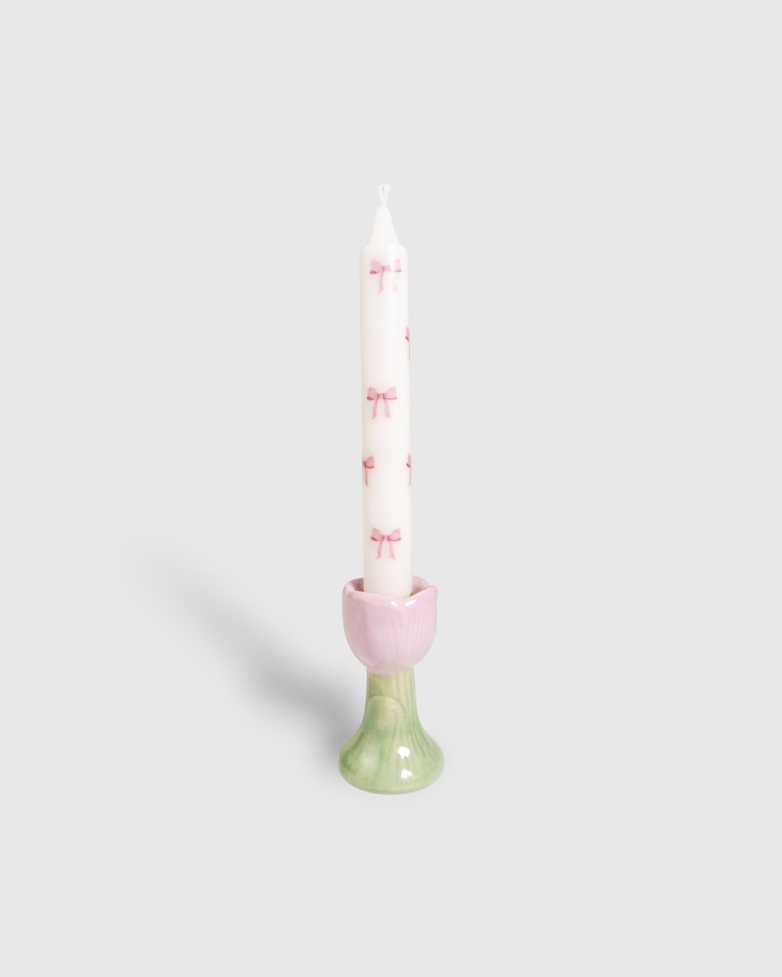 White taper candle with pink bows motifs