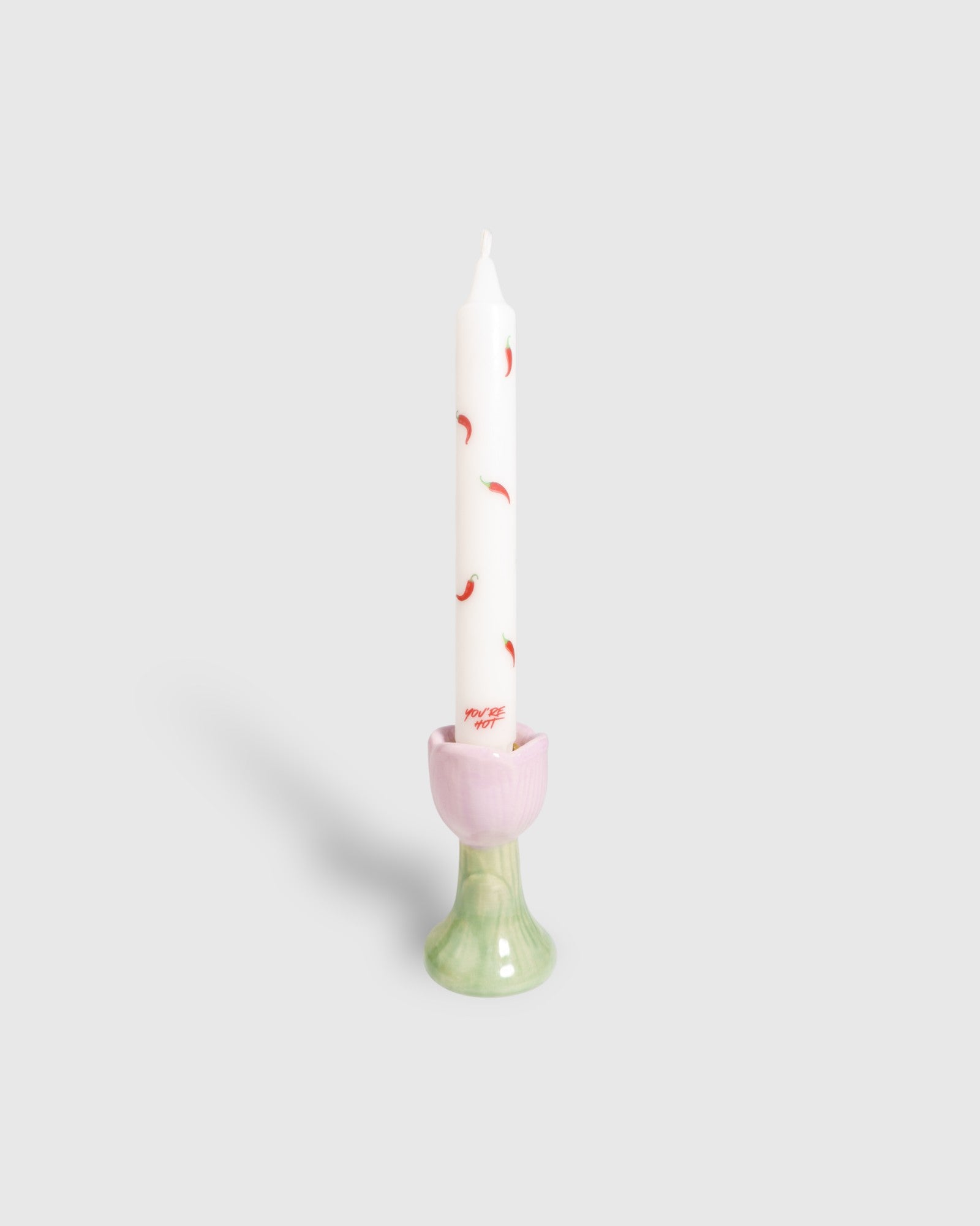 White taper candle with red chilli peppers