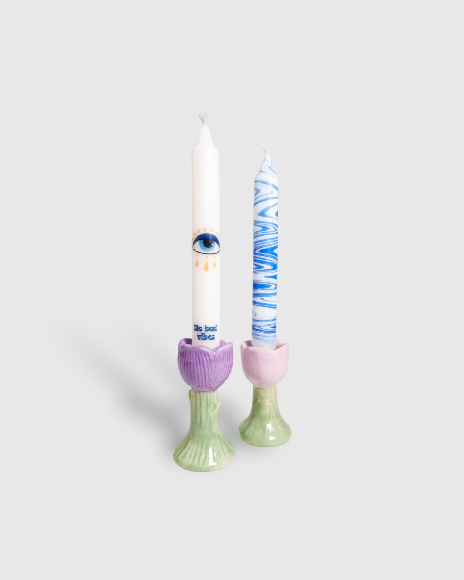 two handmade taper candles in candle holders